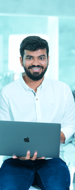 Tekion employee smiling while holding a laptop, showcasing the collaborative tech-driven culture at Tekion